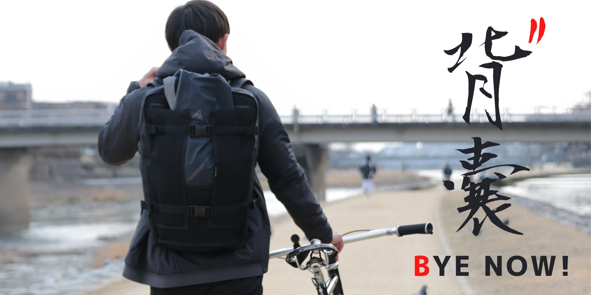 HYNOW(ハイノウ)のウェストバックRIVER(リバー)を背負って鴨川沿いを自転車を転がしながら歩く後ろ姿